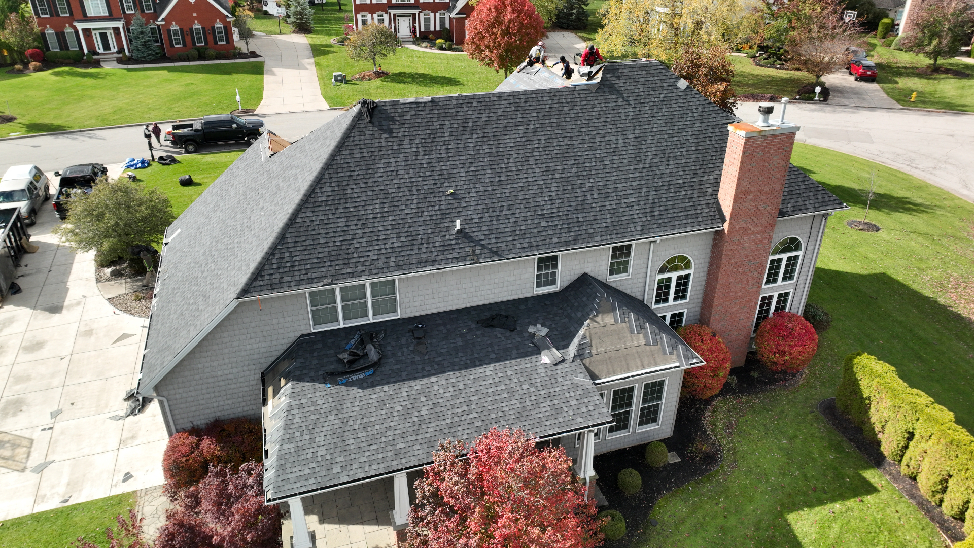 Aerial drone view of a Top Priority roofing crew installing a new shingle roof